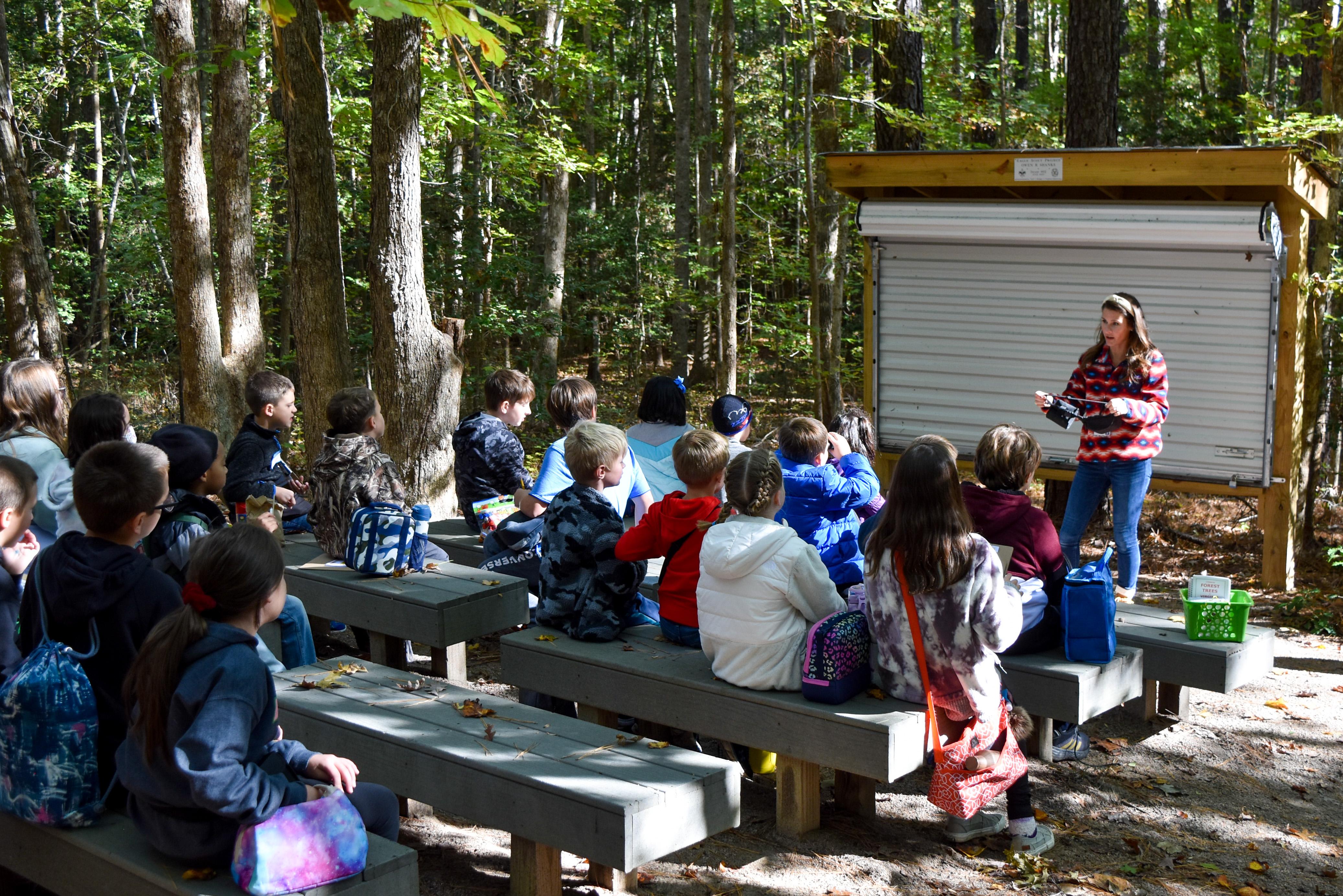Students listen to instructions at the outdoor classroom area.